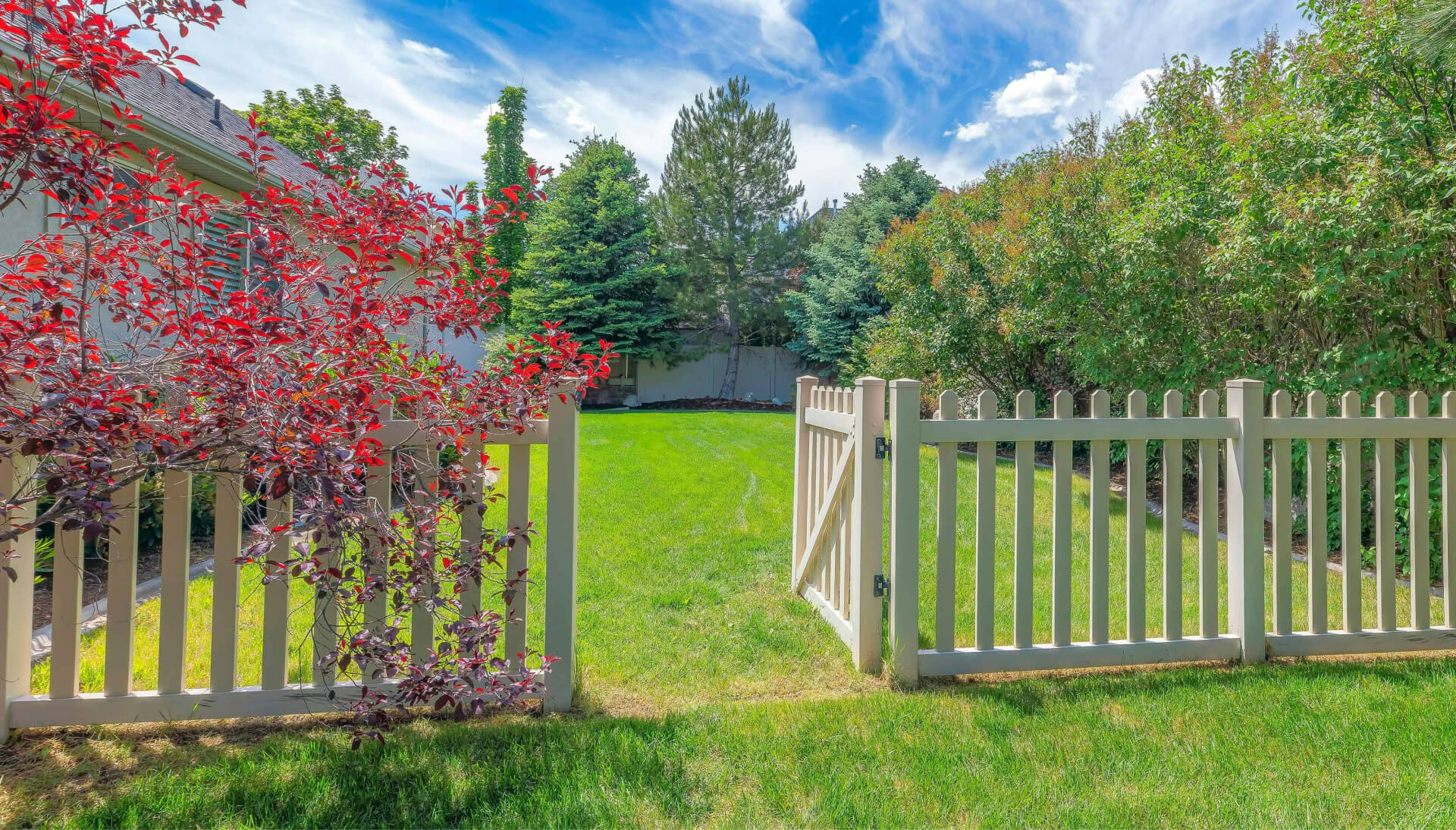 A functional fence gate providing access to a well-maintained backyard, surrounded by a wooden fence in Cumming